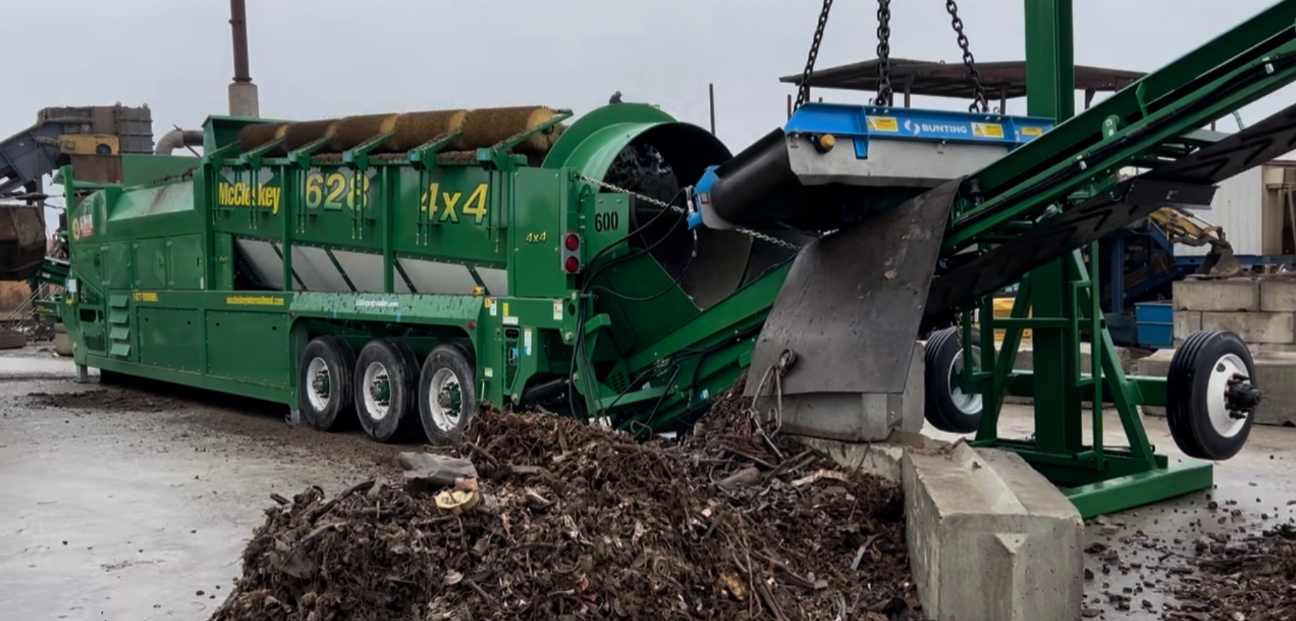 McCloskey 628 trommel screener operating with conveyor system to process organic and bulk materials.