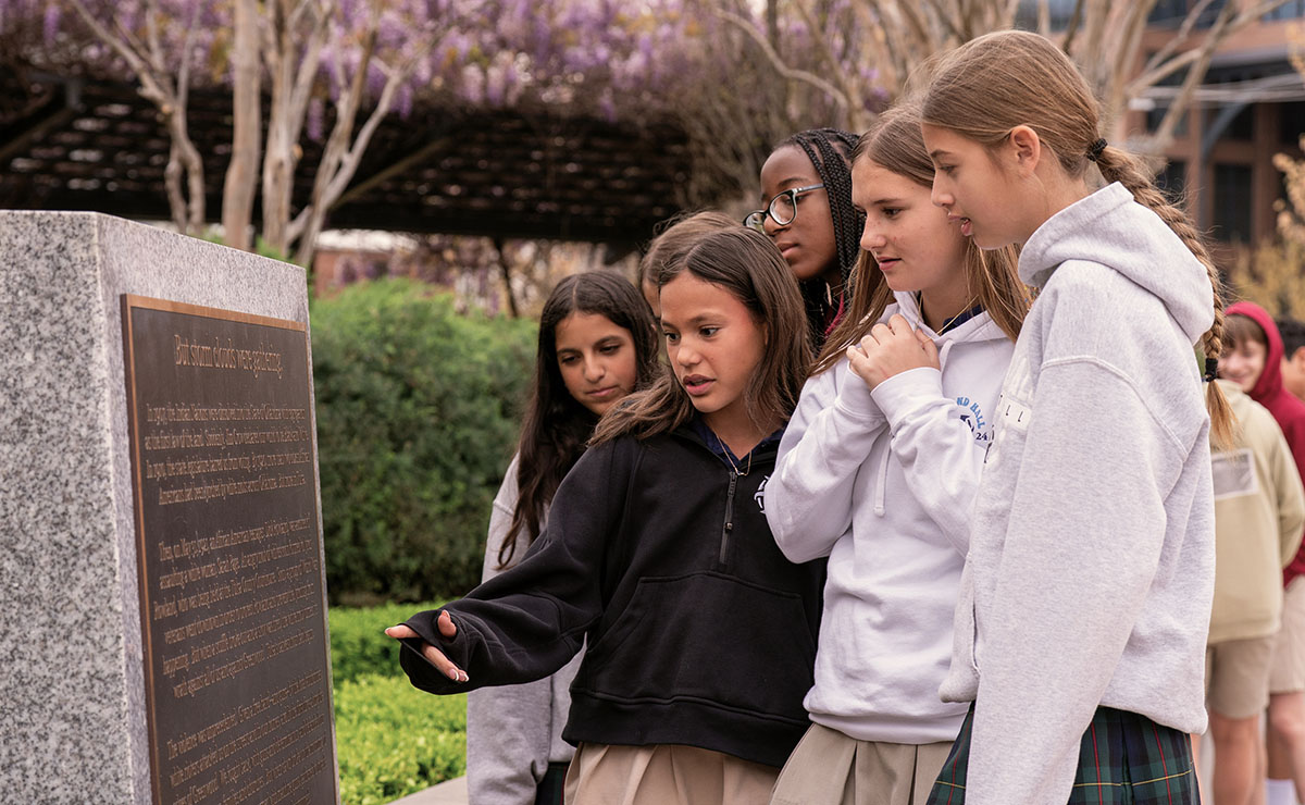 Middle School students read plaque on a field trip to Greenwood.
