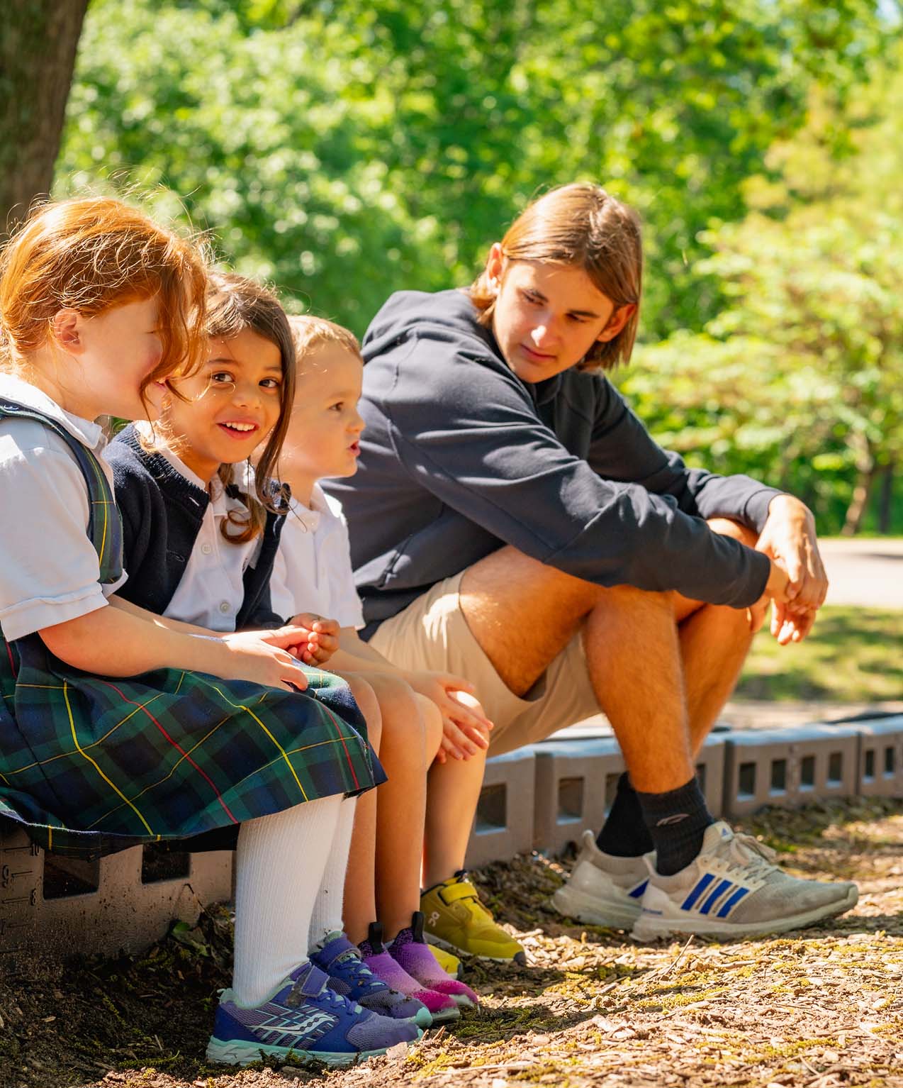 Students of mixed ages sitting together outside.