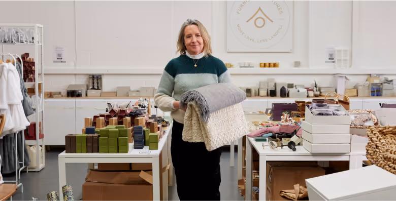 Woman at the Furnishing Futures warehouse holding blankets