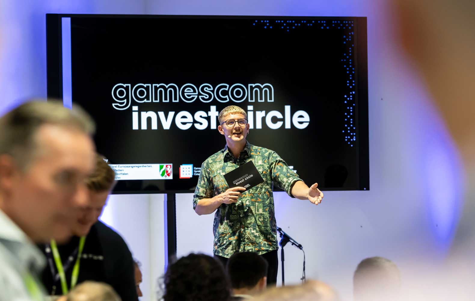 Junger Moderator Benny Ge moderiert eine Konferenz vor Publikum