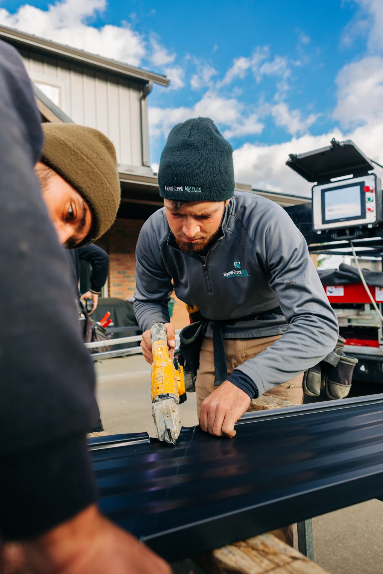 Walnut Creek Metal workers cutting metal roof sheets for a Wayne County home