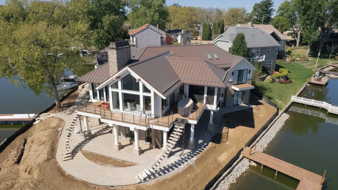 back of home on lake with metal roof