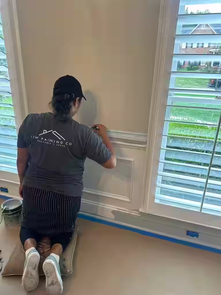 A painter carefully spraying a cabinet door in a controlled workshop environment - Kitchen cabinet painting Charlotte A painter carefully spraying a cabinet door in a controlled workshop environment - Kitchen cabinet painting Charlotte