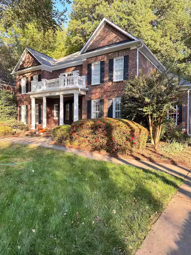 A professional painter carefully painting the exterior of a two-story home - wall painting Charlotte NC A professional painter carefully painting the exterior of a two-story home - wall painting Charlotte NC