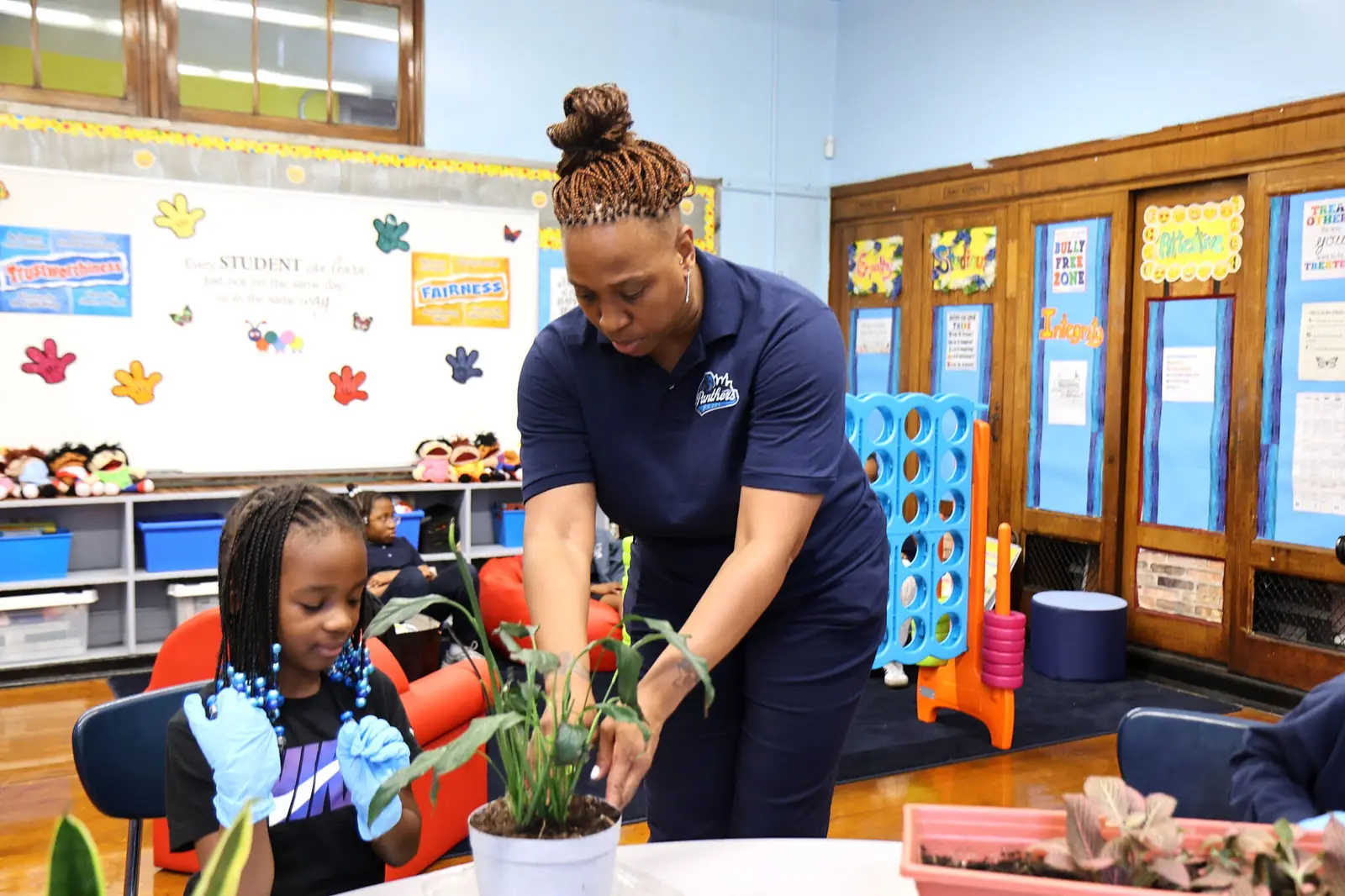 Teacher and student planting together in classroom