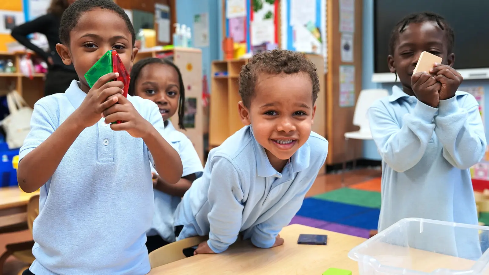 Students exploring geometry with colorful pattern blocks in classroom