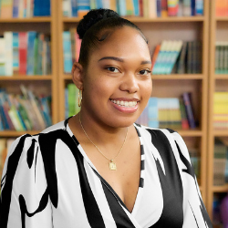 Jessica Phillips smiling in front of a library bookshelf