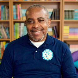Jonathan Woodley smiling in front of a bookshelf