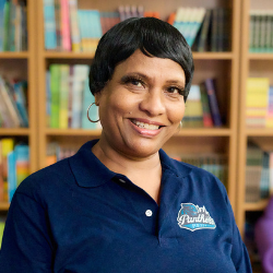 Savitree Williams smiling in front of a bookshelf
