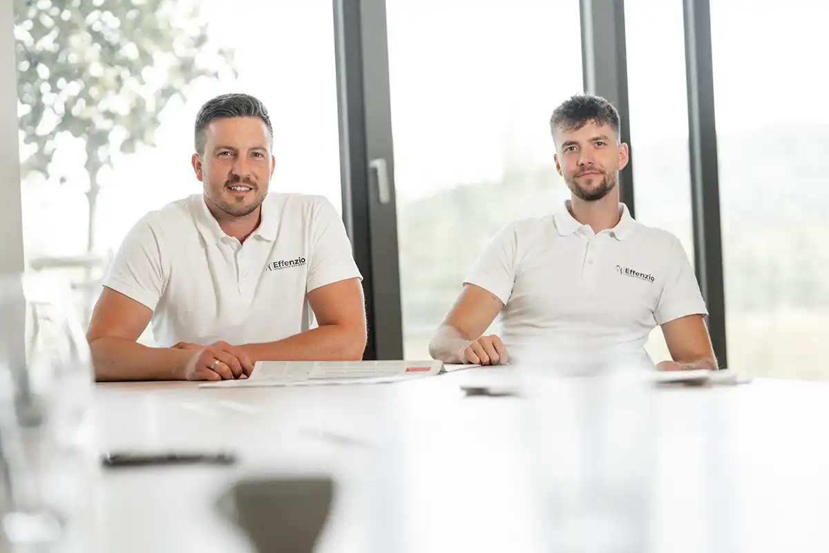 Maximilian und Jan sitzen und schauen in die Kamera