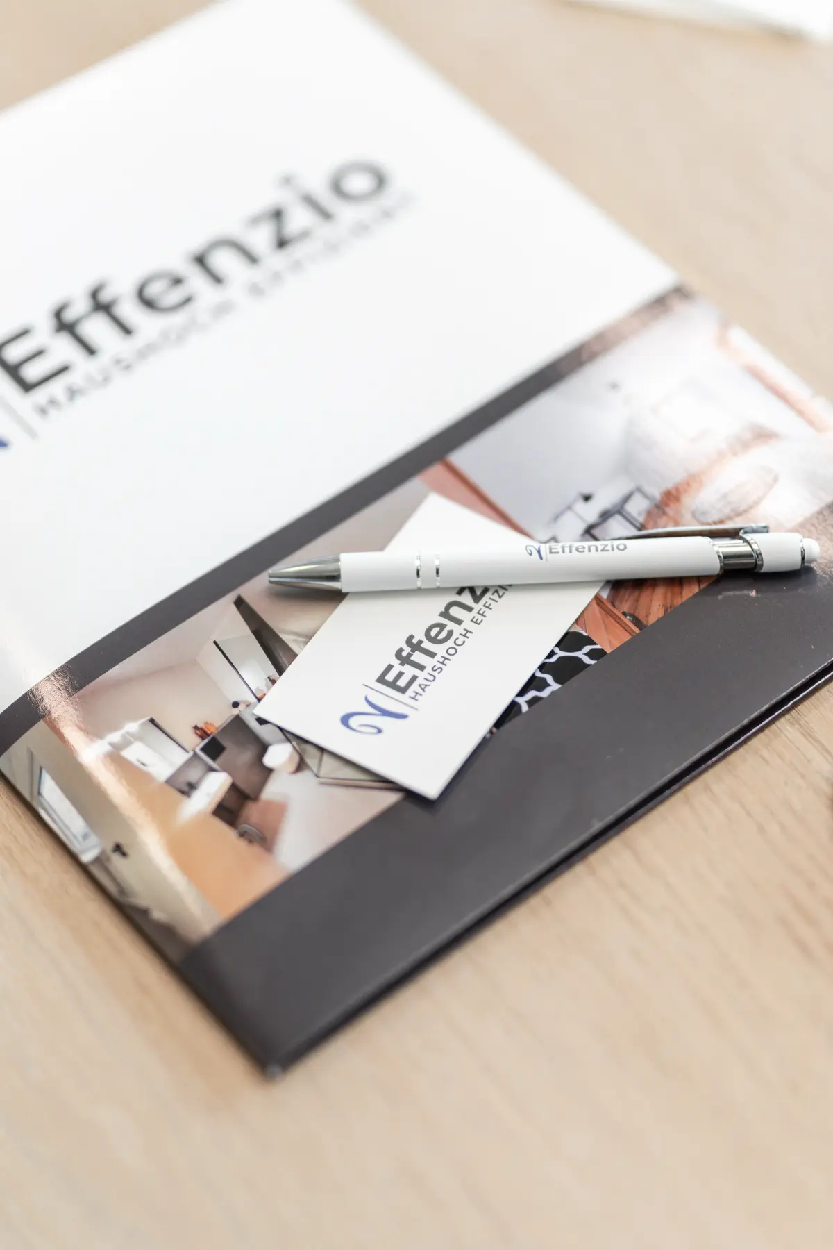 auf einem Tisch liegt eine Effenzio Mappe mit Visitenkarte und Stift