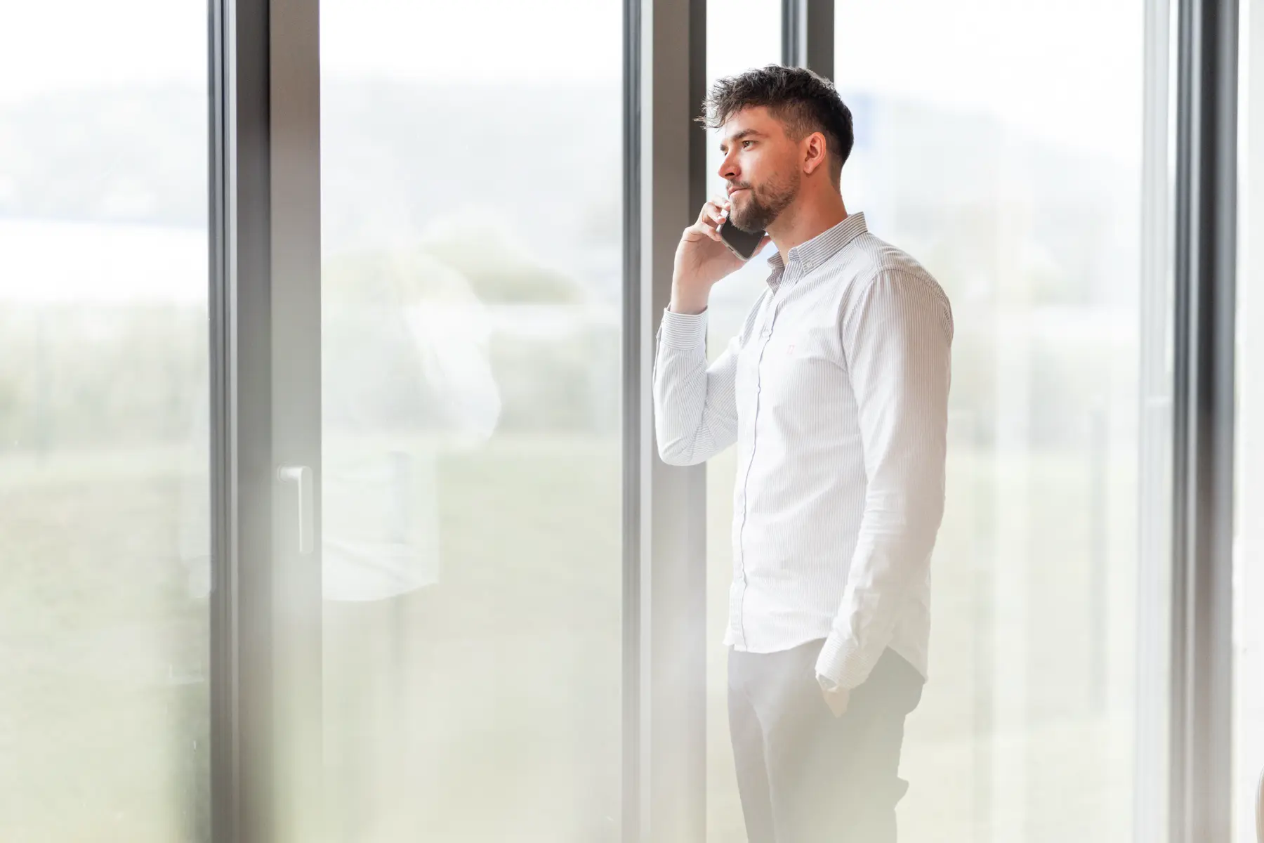 Maximilian telefoniert und sieht aus dem Fenster