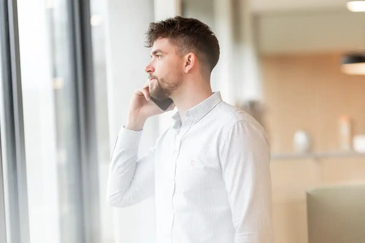 Maximilian am Telefon sieht aus dem Fenster