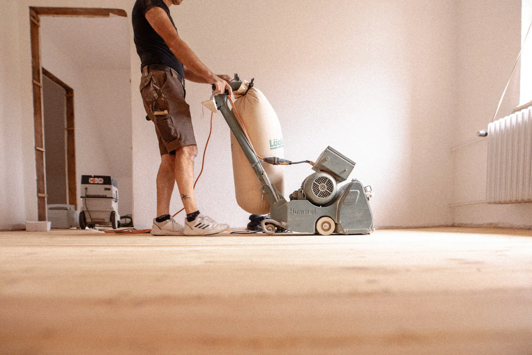 Mann arbeitet mit einer Maschine am Boden