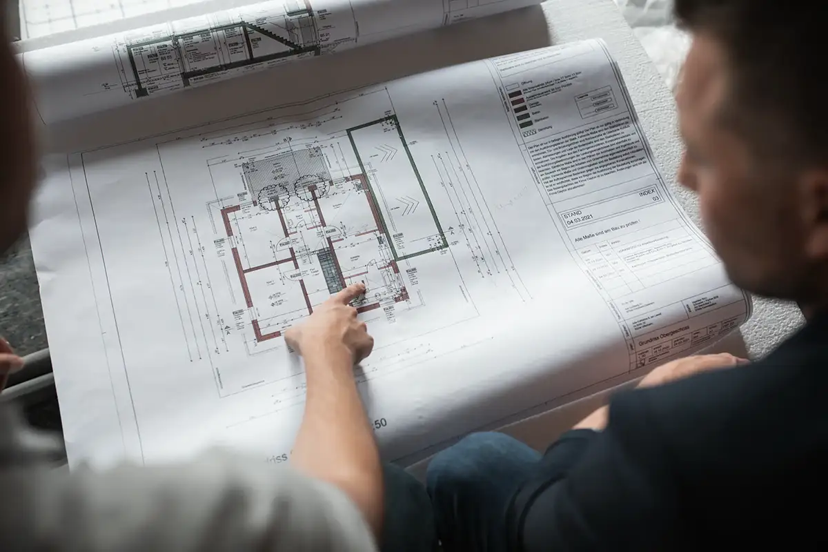 Zwei Personen inspizieren eine Bauplan