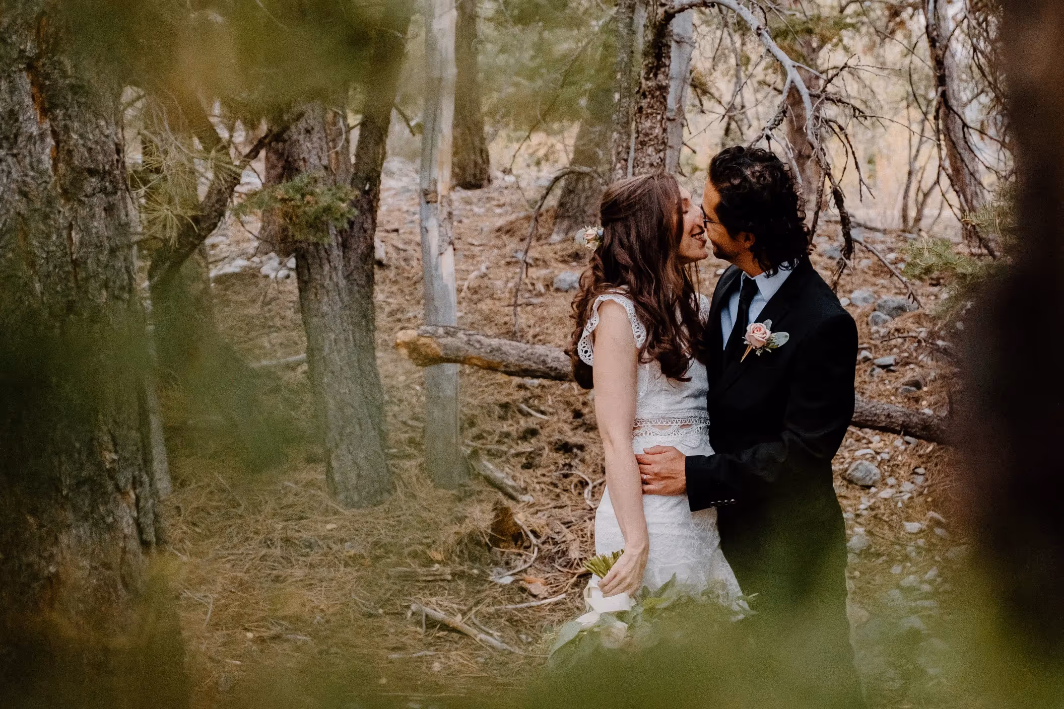 Elise and Sebastian's intimate Mount Charleston elopement, couple sharing a romantic moment in a secluded forest setting near Las Vegas