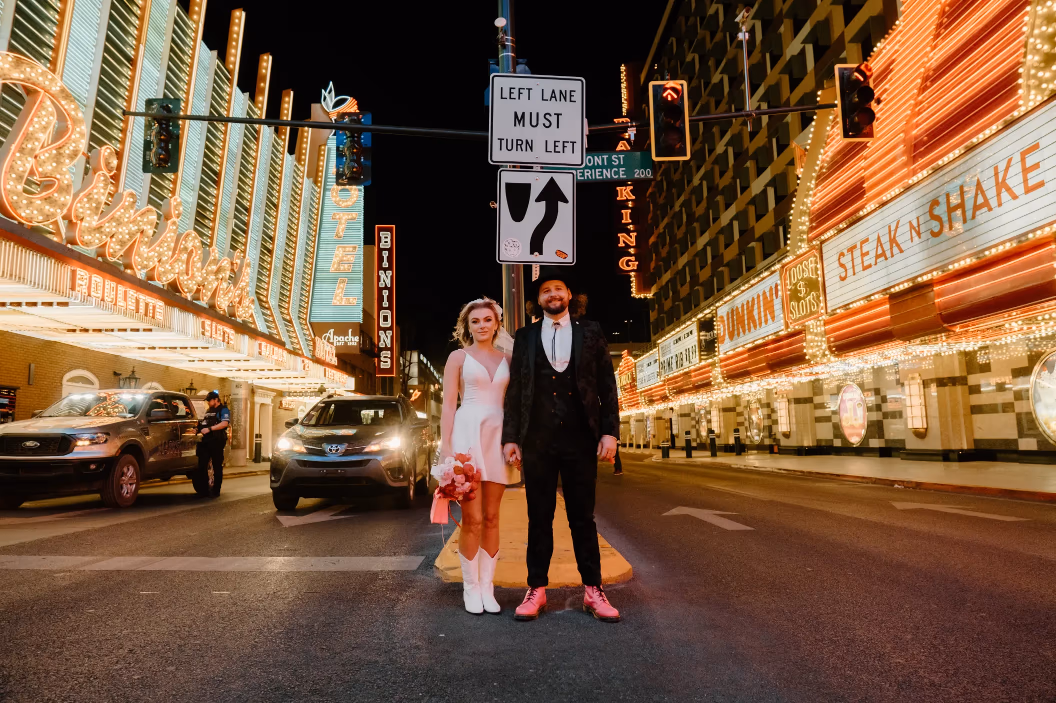 Anoushka and Matt's unique Las Vegas elopement, couple posing on Fremont Street surrounded by classic neon signs and vintage casinos