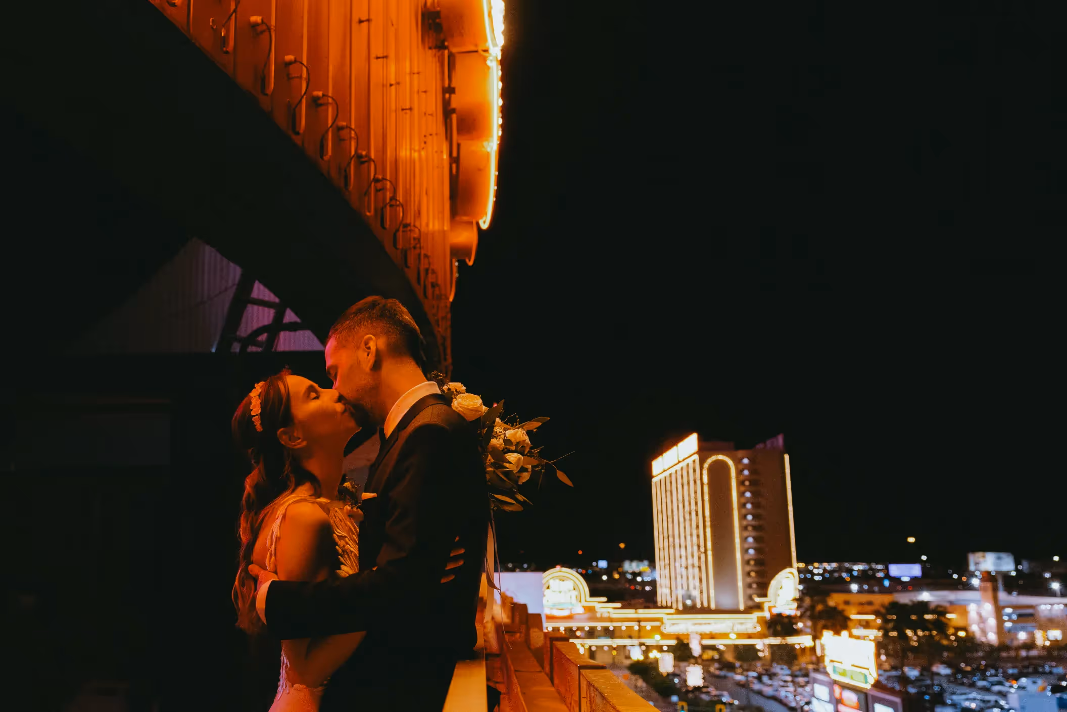 Zsofia and Mate's romantic Las Vegas wedding, sharing an intimate kiss on a rooftop overlooking the dazzling downtown skyline