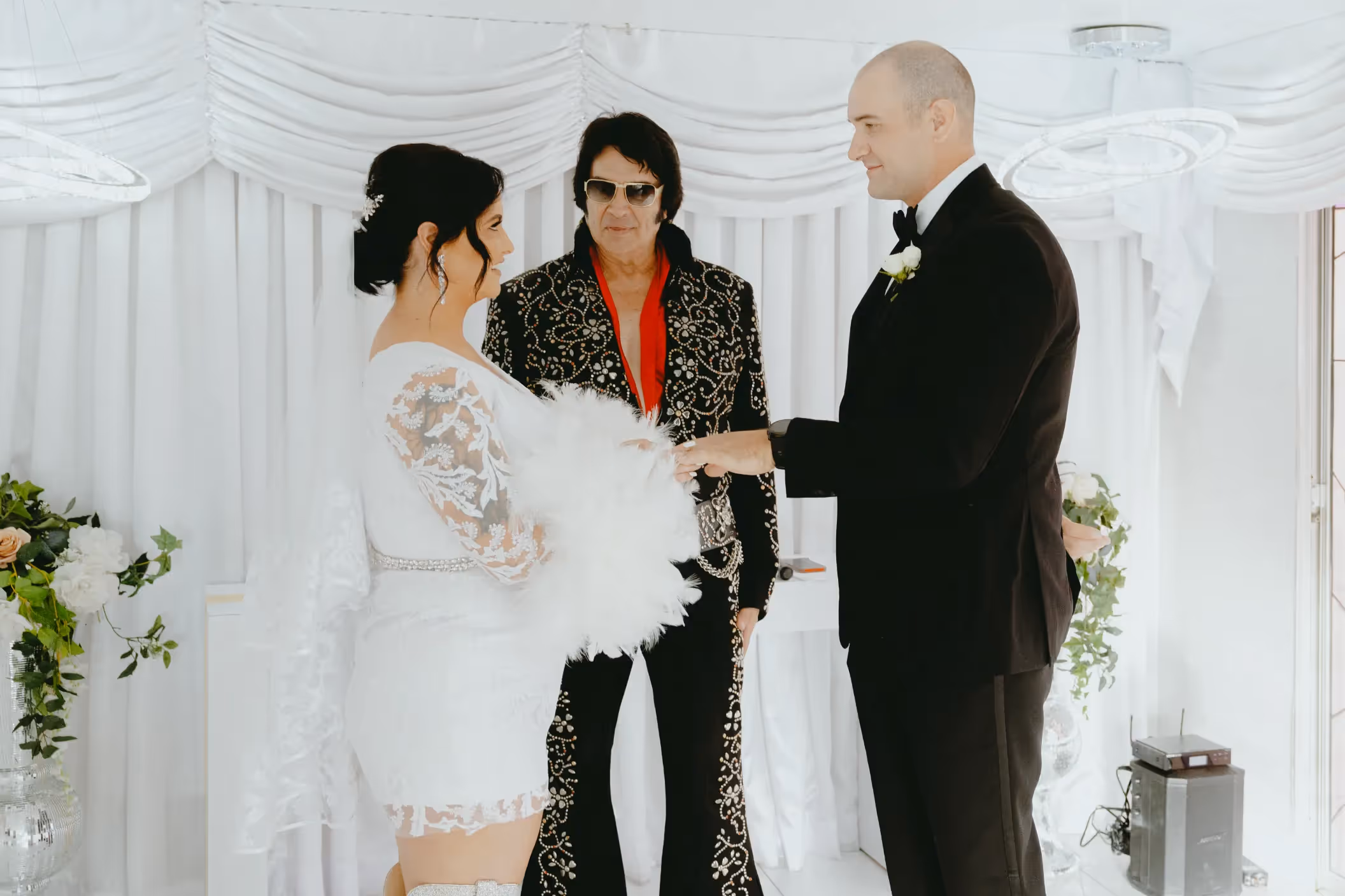 Hope and Jonathan's intimate Las Vegas chapel wedding, with Elvis officiating their stylish ceremony in white-draped setting