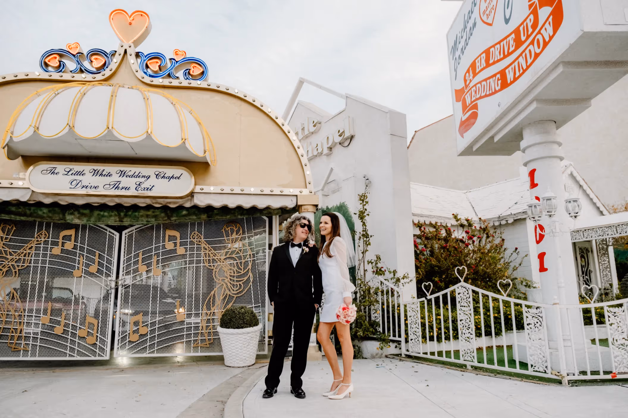 Claire and Daniel's classic Las Vegas wedding at the iconic Little White Wedding Chapel, posing by the famous 'Drive Thru' tunnel