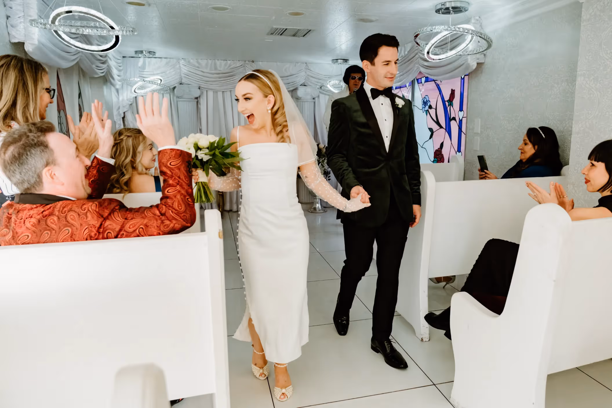 Paige and Lloyd's joyful Las Vegas chapel elopement, newlyweds celebrating with guests and Elvis in retro-styled venue