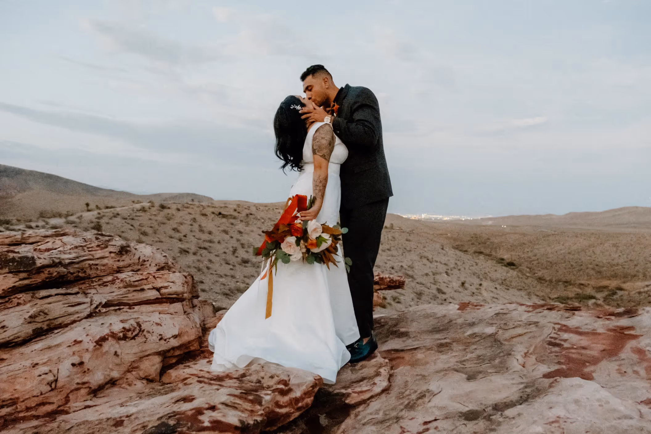 Reyna and Damion's Las Vegas elopement at Red Rock Canyon, hugging in a picturesque desert landscape