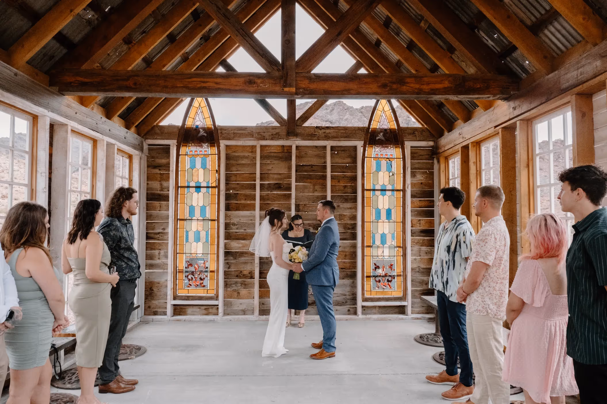 Elopement of Nicole and Jordan at Nelson Ghost Town, featuring rustic chapel and desert landscape with guests seated outdoors