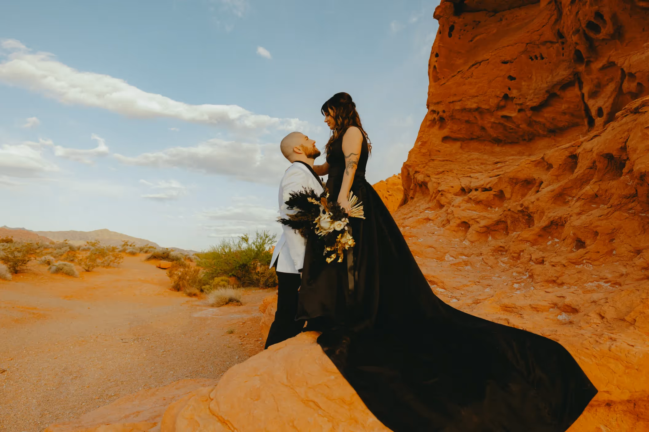 Ryleigh and Tyson's dramatic Valley of Fire wedding portrait, featuring the bride in a flowing black gown contrasting with the vibrant red sandstone cliffs