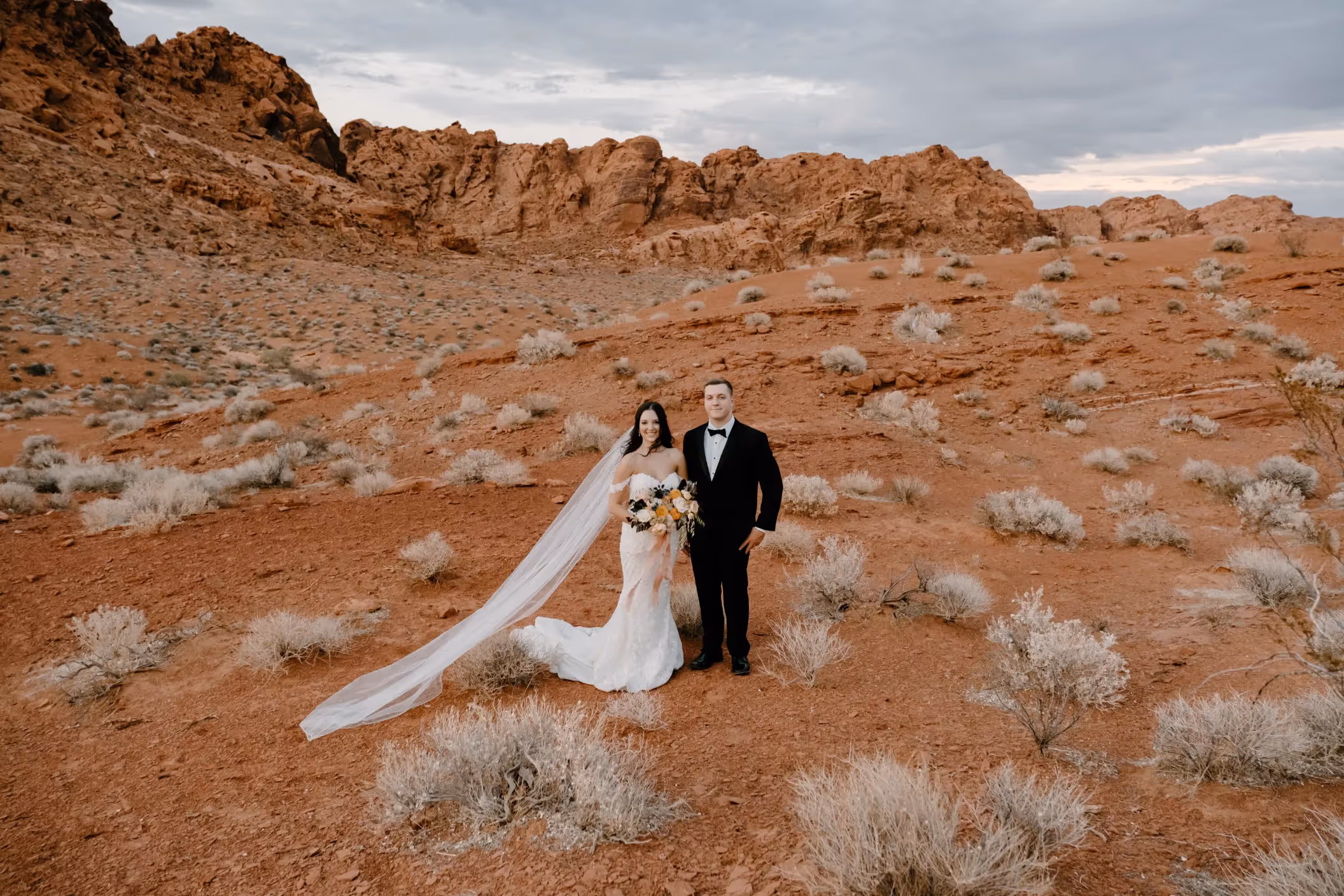 Olivia and Thomas' elegant Valley of Fire wedding portrait, showcasing the couple's love against a backdrop of rugged desert terrain