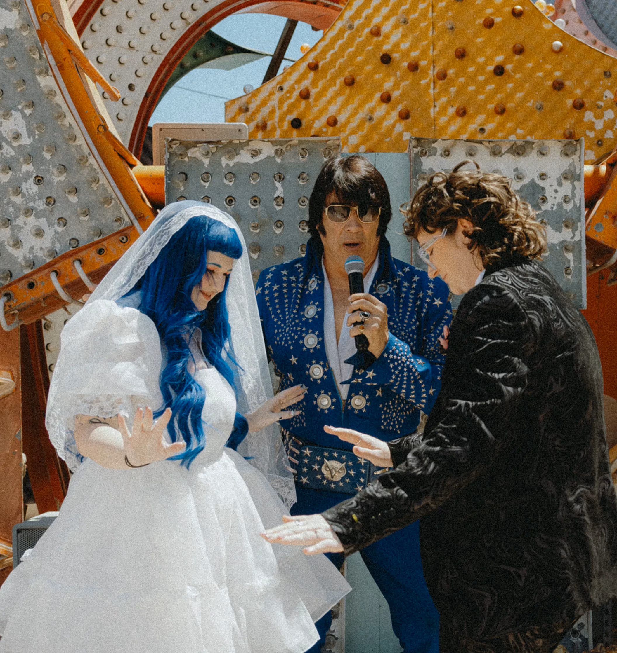 Caity and Ryan's unique Las Vegas wedding at the Neon Museum, bride in polka dot dress with orange bouquet posing by vintage "New York" sign