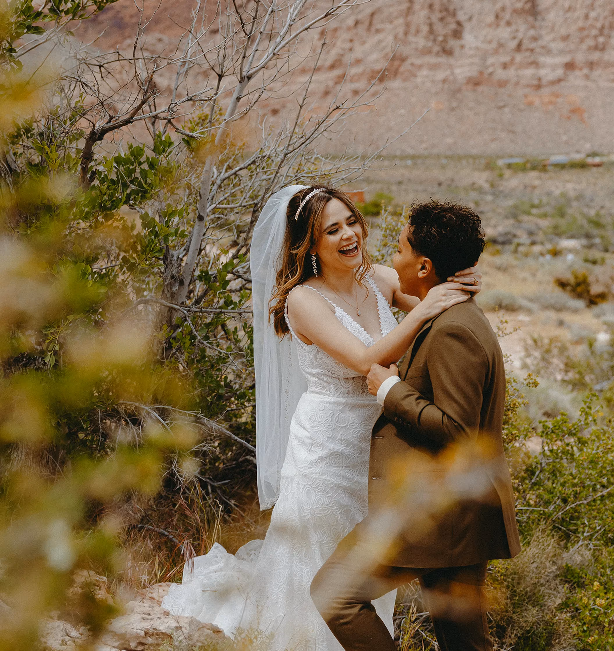 Personalized Las Vegas elopement: Jennifer and Mayur kiss at sunset with dramatic desert mountains, demonstrating cultural fusion in non-traditional wedding