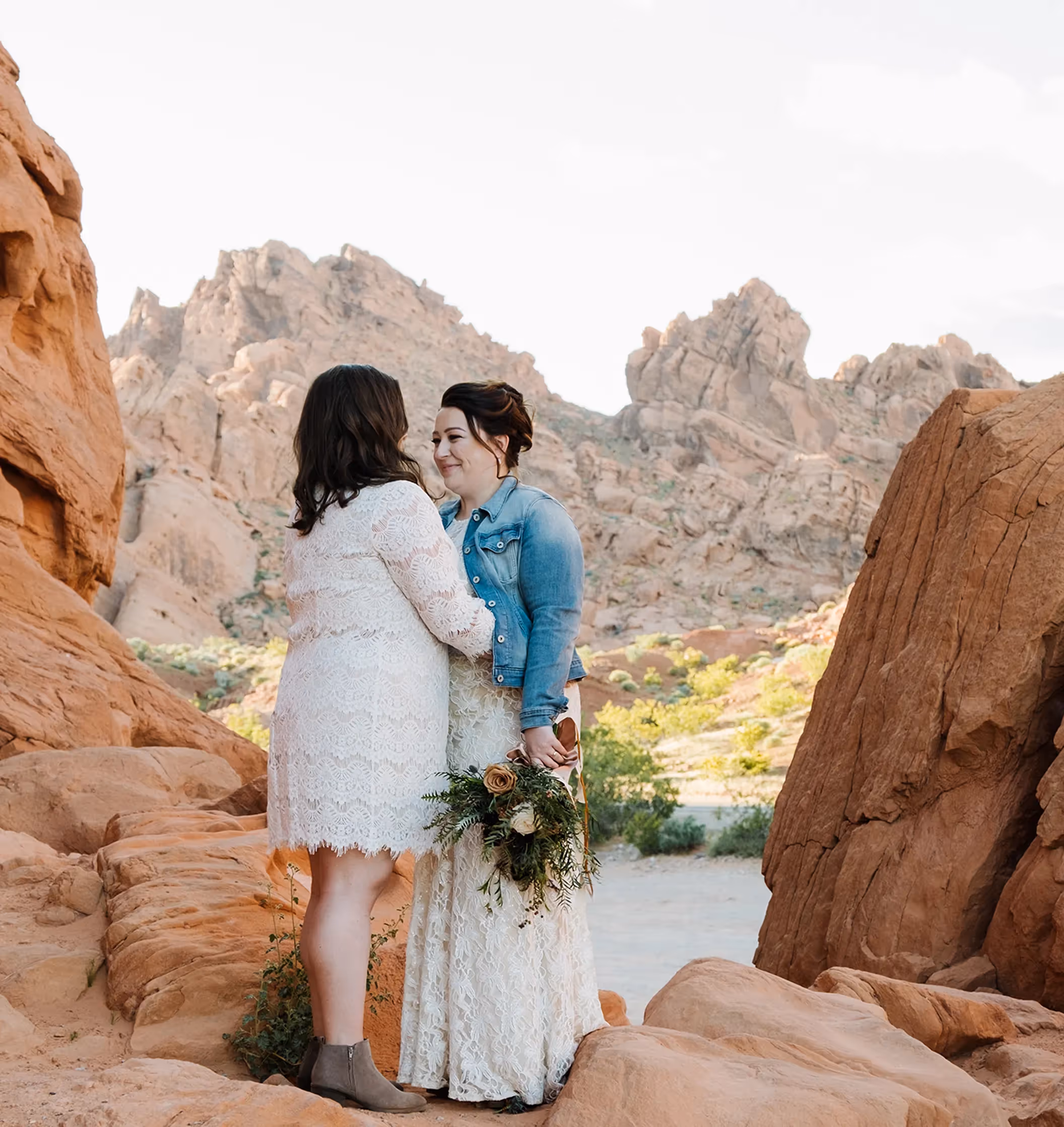 Meggan and Erin's rustic-chic Valley of Fire wedding portrait, showcasing the couple's love surrounded by the park's stunning red rock cliffs and desert flora