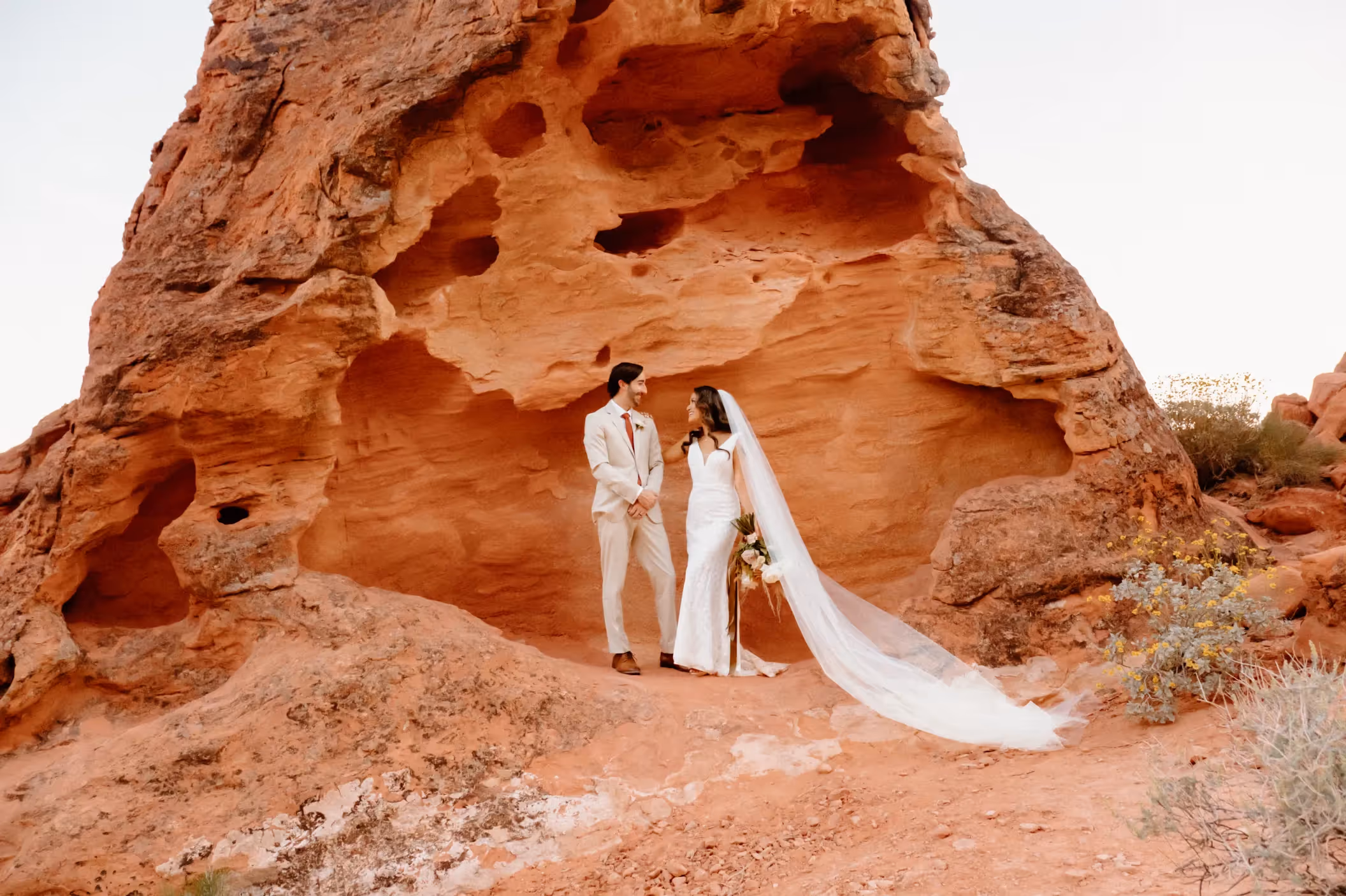Kim and Connor's breathtaking Valley of Fire elopement, the newlyweds posing before towering red cliffs in the heart of the Nevada desert
