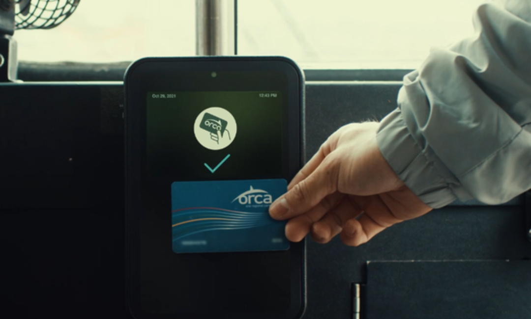 Man taps card on public transit payment reader