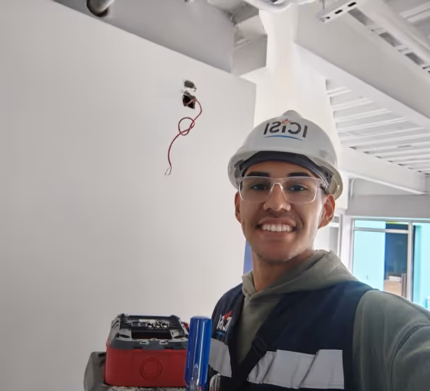 Un colaborador de ICISI sonriendo mientras instala un sistema contra incendios.