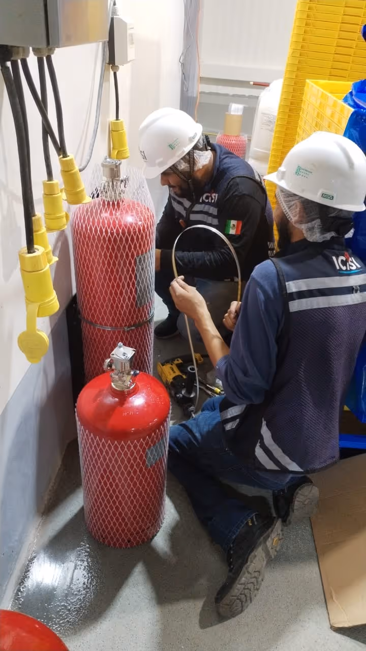 Un colaborador de ICISI sonriendo mientras instala un sistema contra incendios.