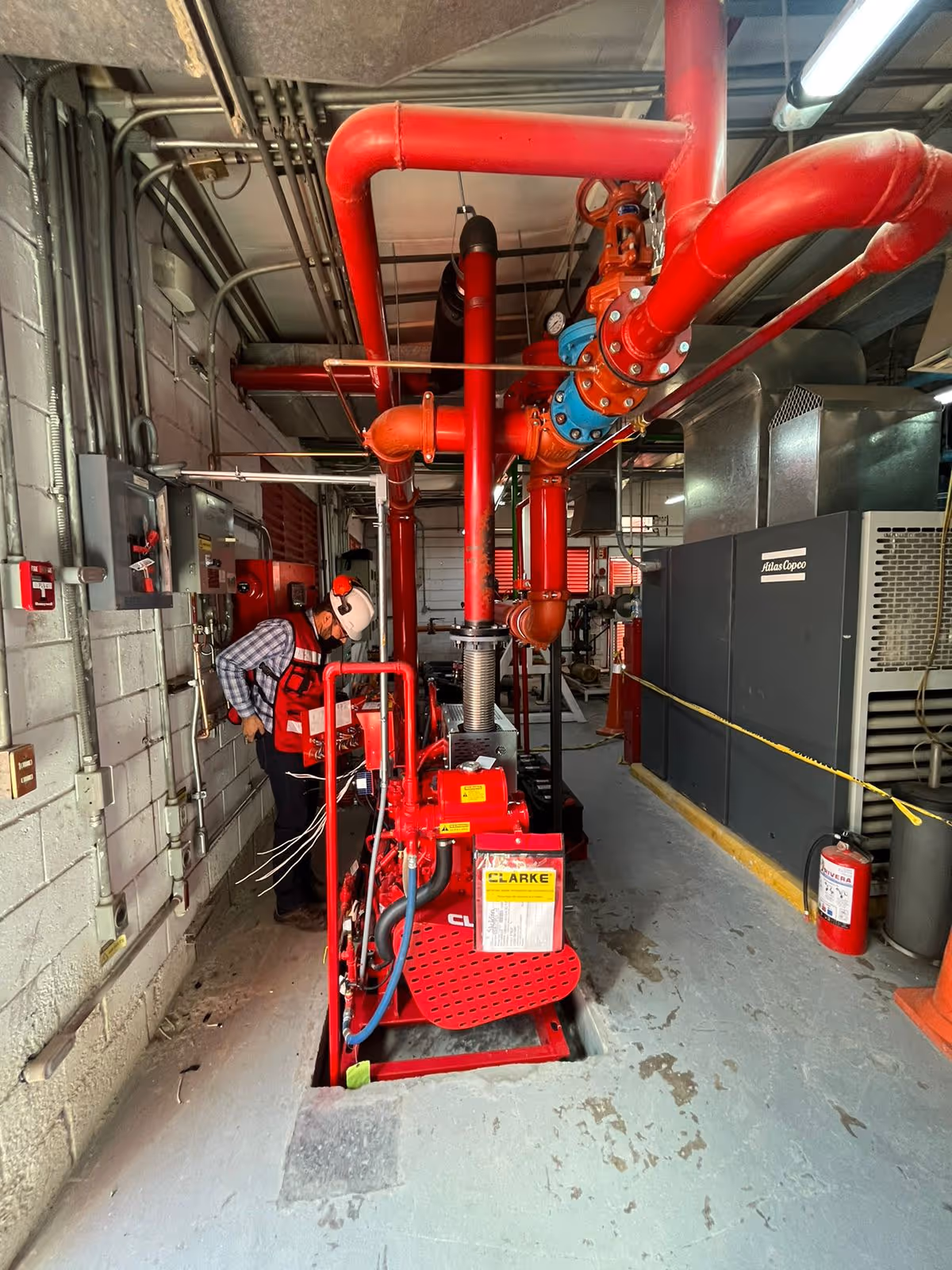 Un colaborador de ICISI sonriendo mientras instala un sistema contra incendios.