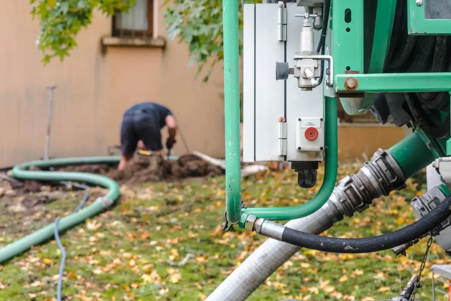 A plumber working on repairing a sewer line pipe with a machine 