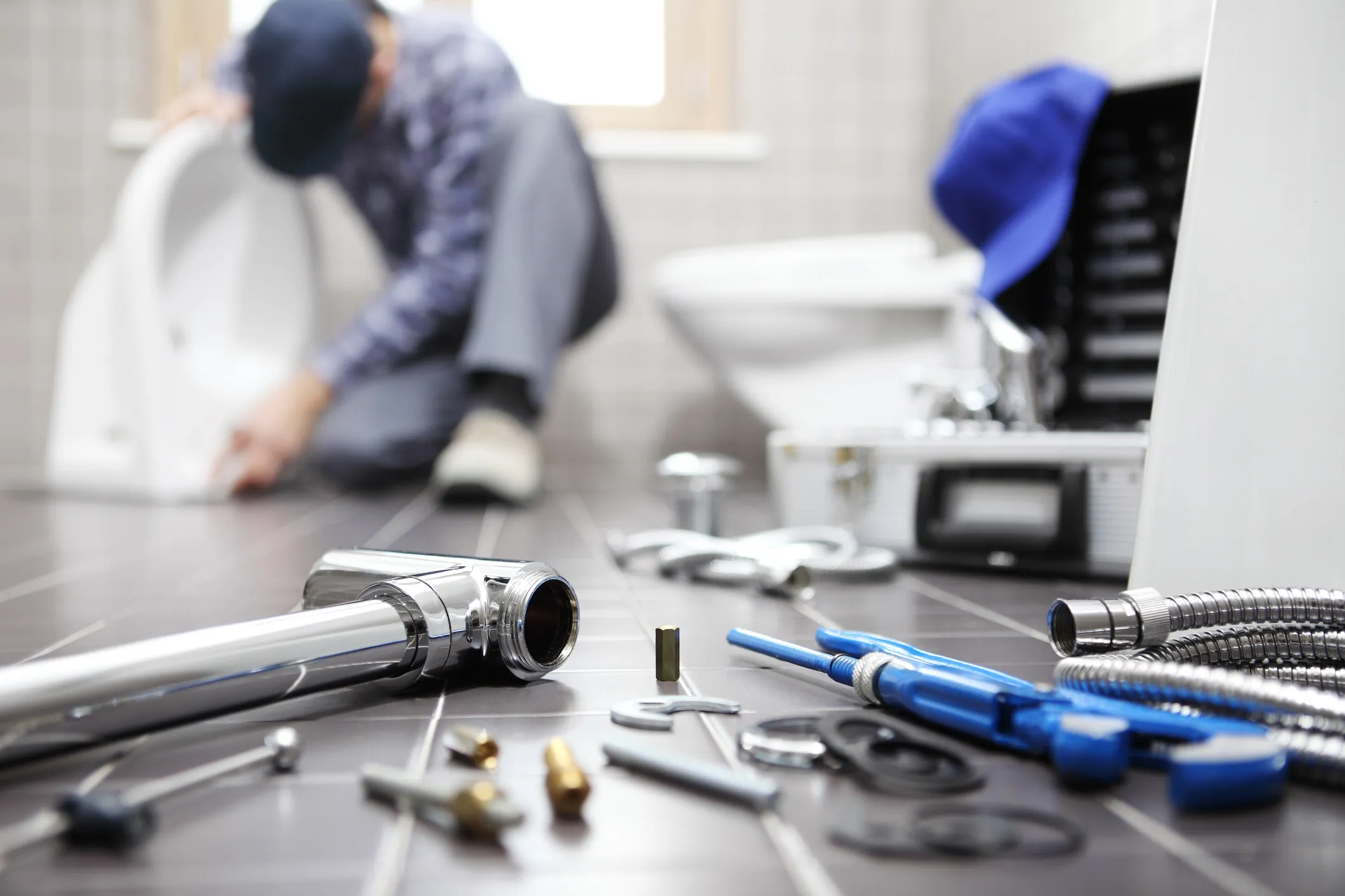 A tools placed in the floor where as a person is repairing behind