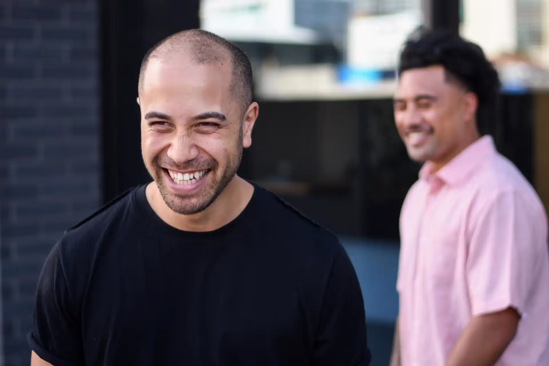 Two men standing next to each other smiling