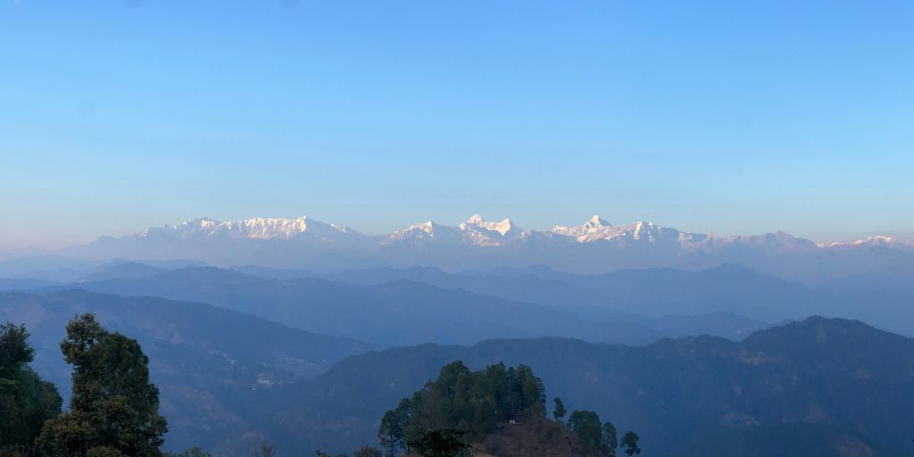 a view of a mountain range with snow capped mountains in the distance