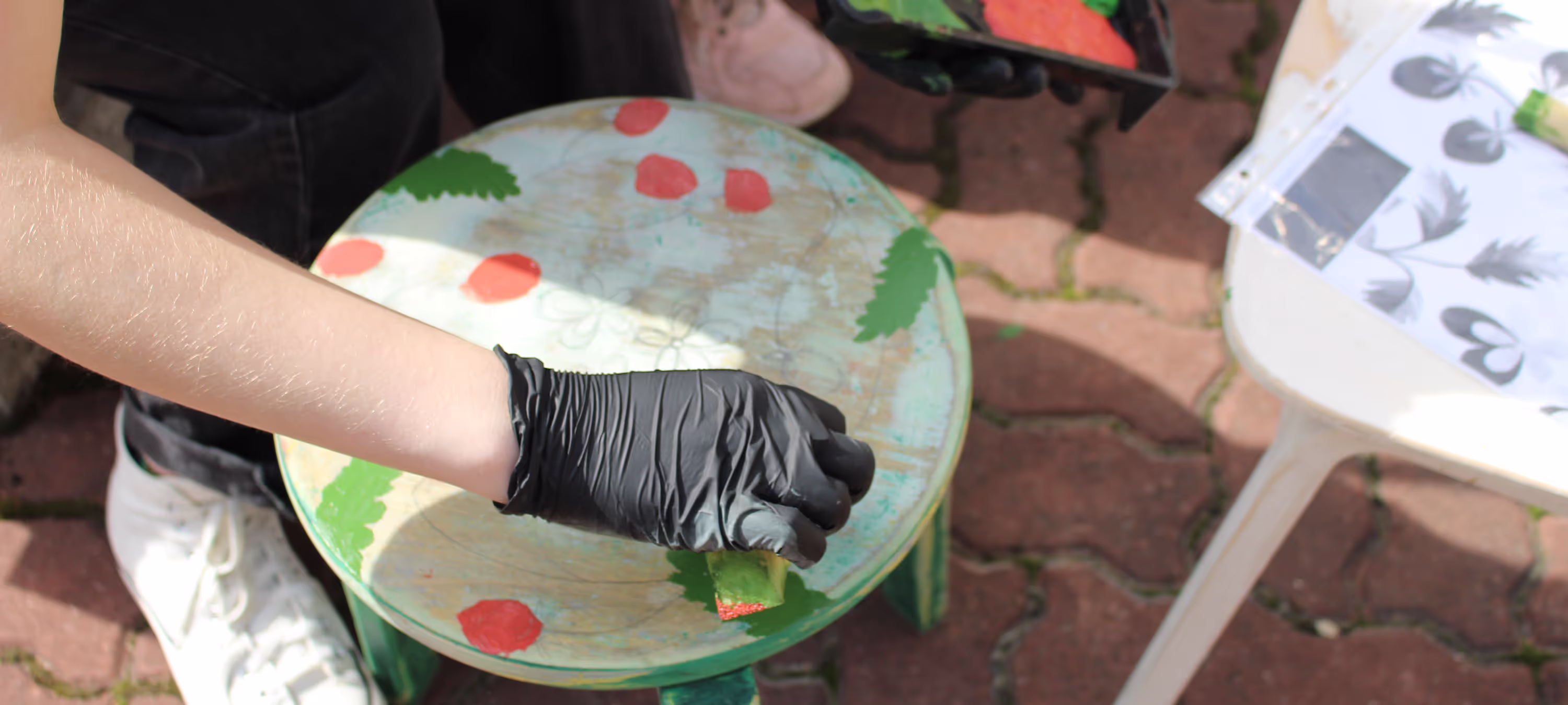 Student working on painting a stool.