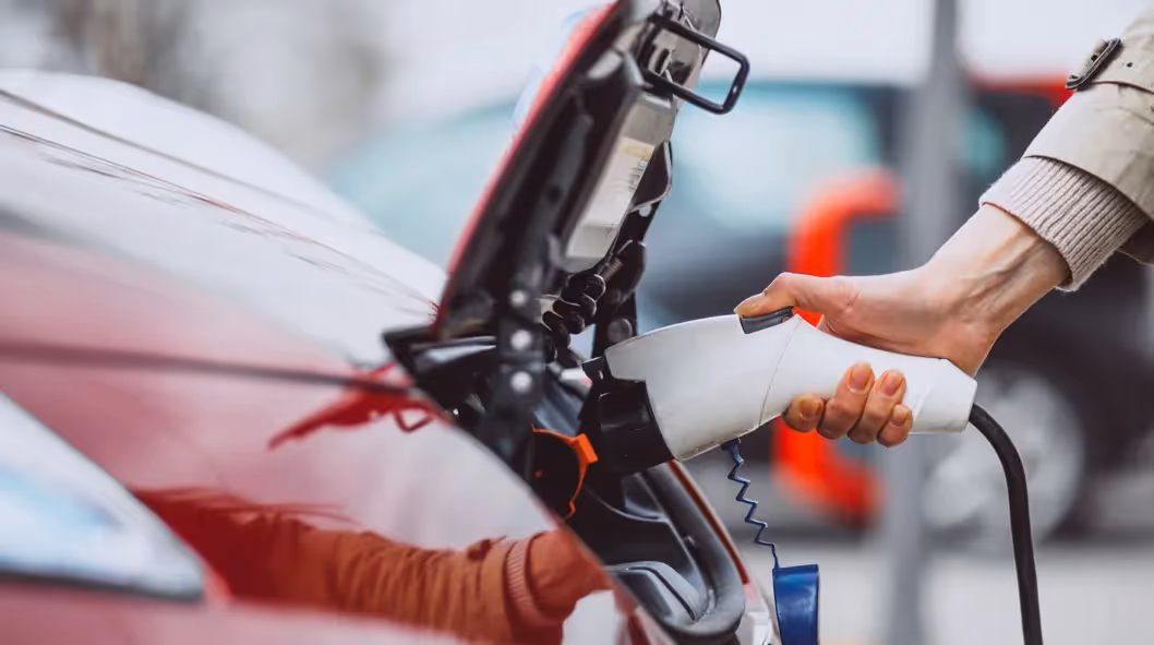 Un homme recharge la batterie BEV de son véhicule électrique.