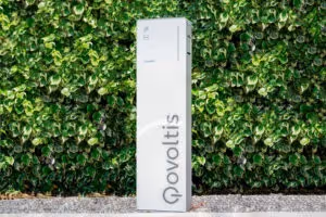 borne de recharge Qovoltis derrière des arbustes