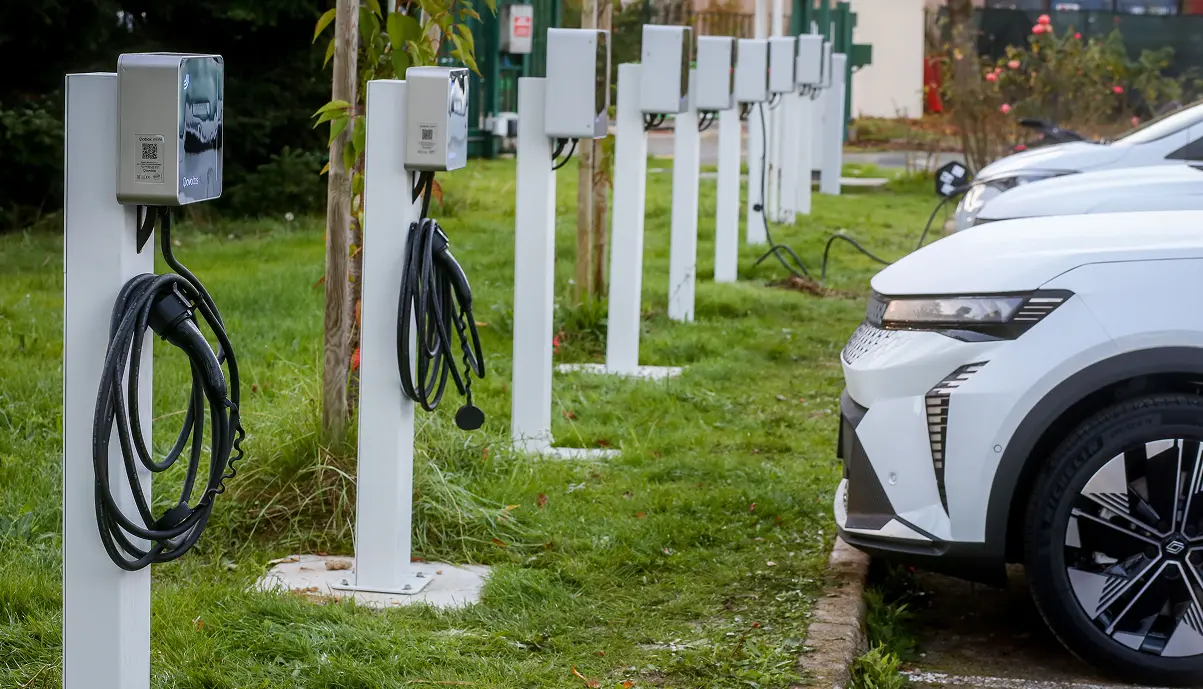 Row of Qovoltis Qobox mini EV charging stations in a company parking lot, electric vehicle charging