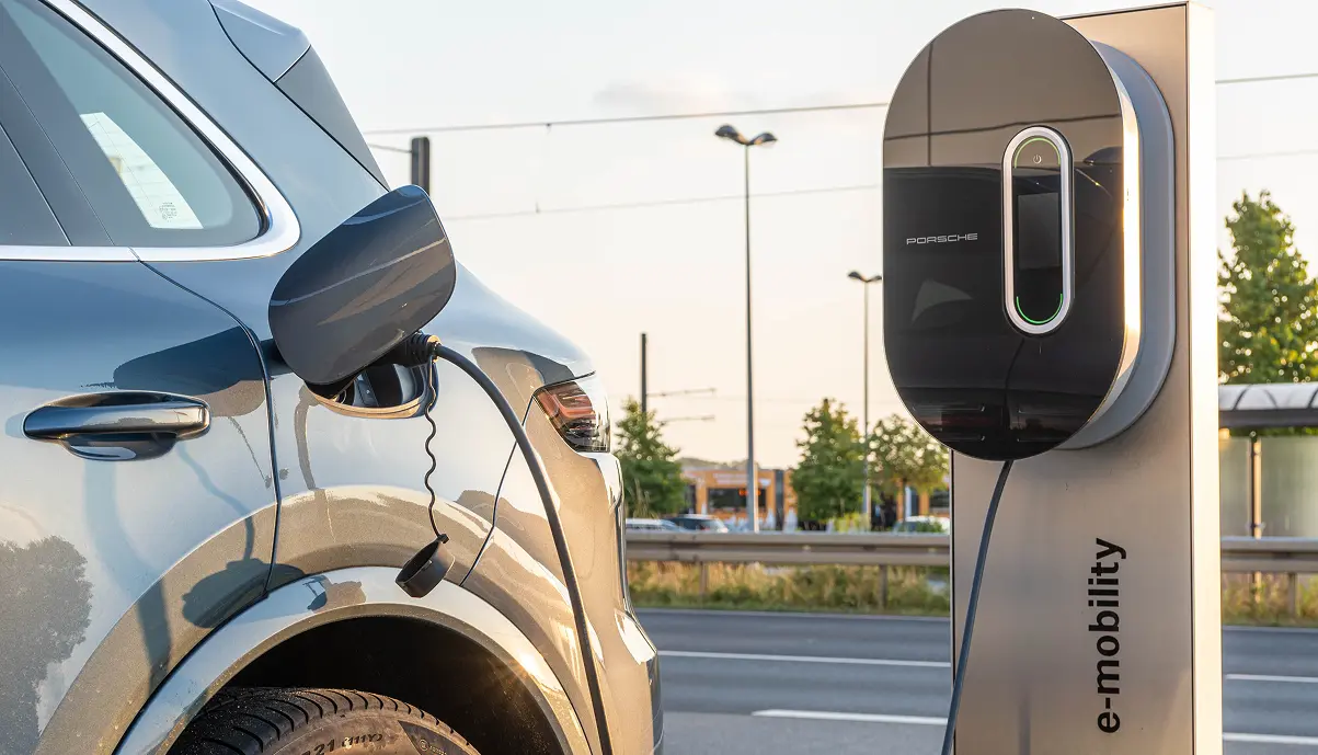 Véhicule Porsche en charge sur une borne du programme Porsche Destination Charging à l'entrée d'un hôtel