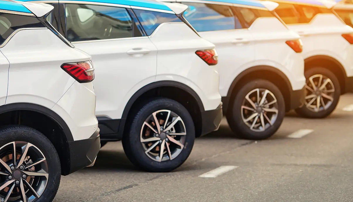 Rangée de SUV blancs garés côte à côte sur un parking, comme une flotte de véhicules d'entreprise