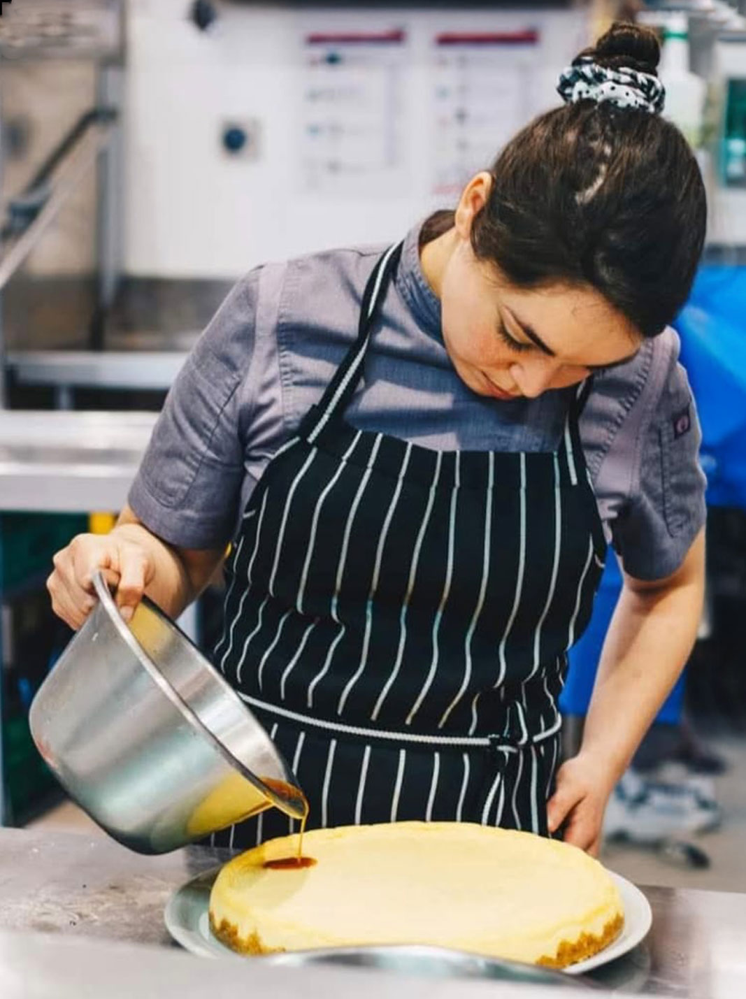 Mariolis, head chef at El Faro Café, preparing a dish in the kitchen.