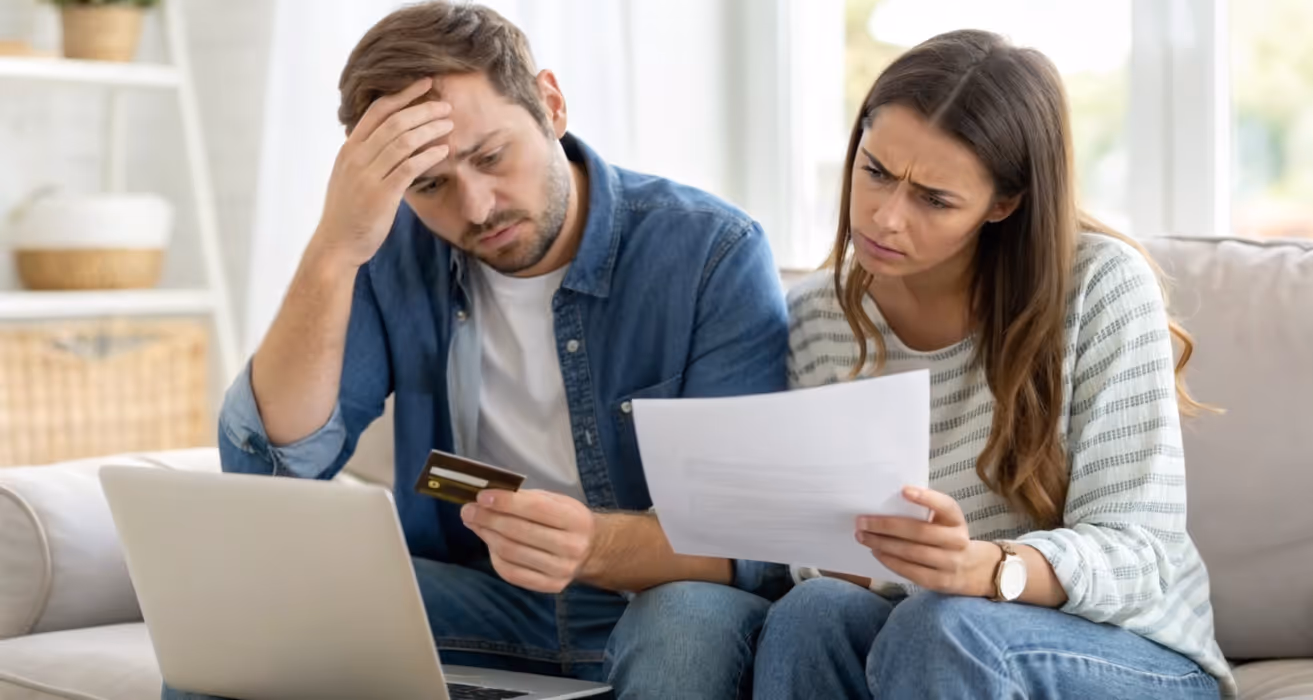Overdue mortgage notice and worried homeowner at a table are depicted to show financial hardship and payment challenges."